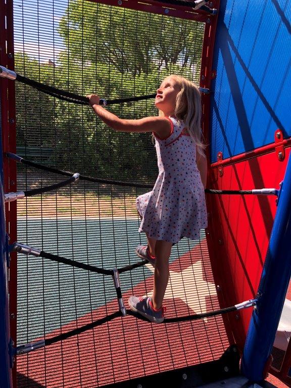 Girl climbing ropes in play structure at Veterans Park