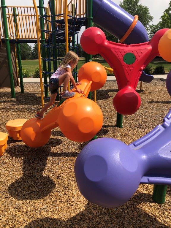Girl climbing at playground in Firestone
