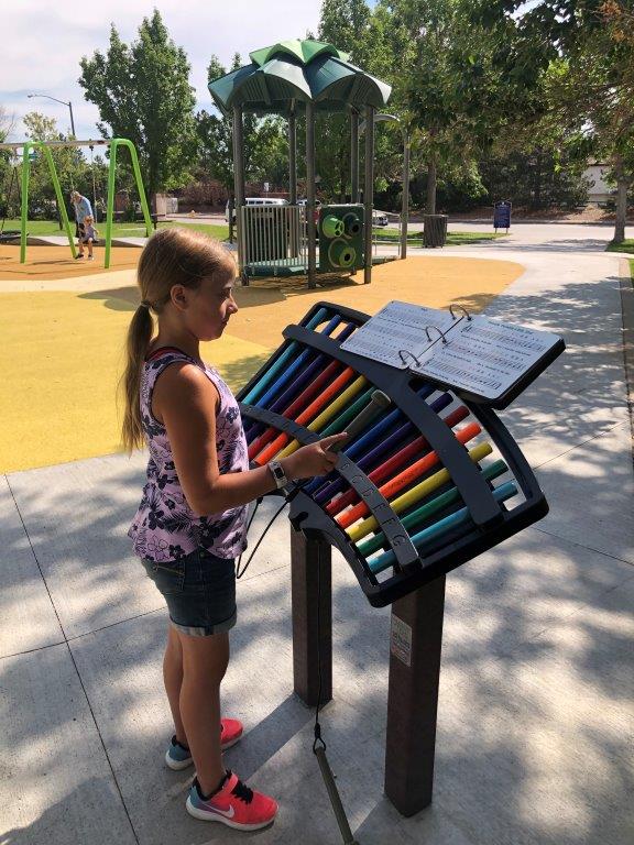Girl playing xylophone at new playground in Aurora