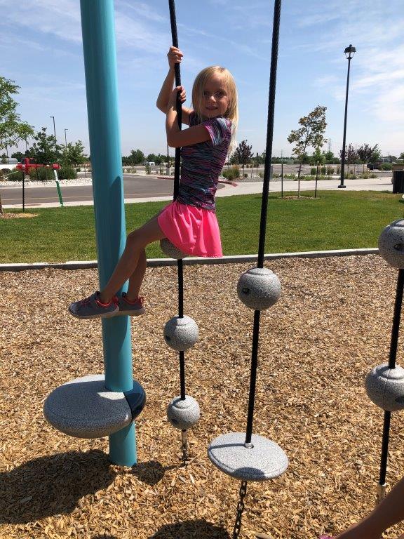 Girl holding rope obstacles at Riverwalk Park