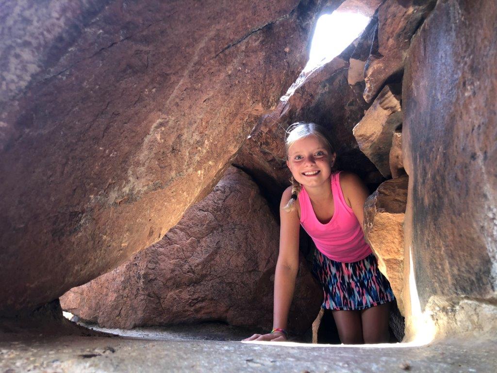 Girl popping through cave opening in Boulder