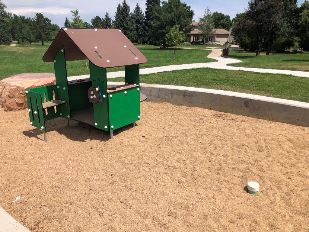 Sandbox with small playhouse at park in Boulder