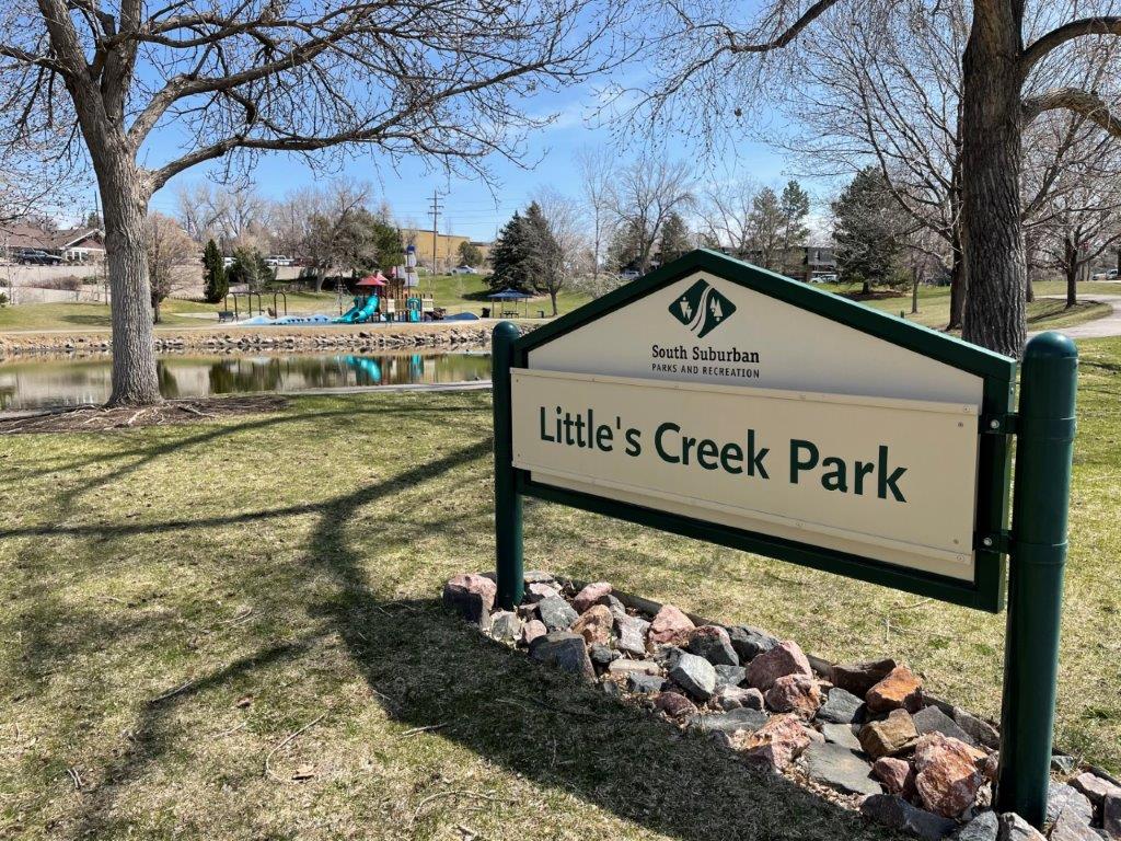 Littles Creek Park sign and view of playground across lake