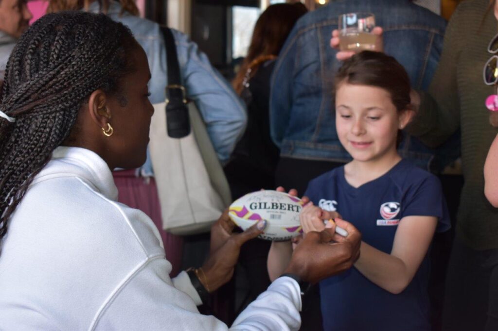 Naya Tapper signing a rugby ball