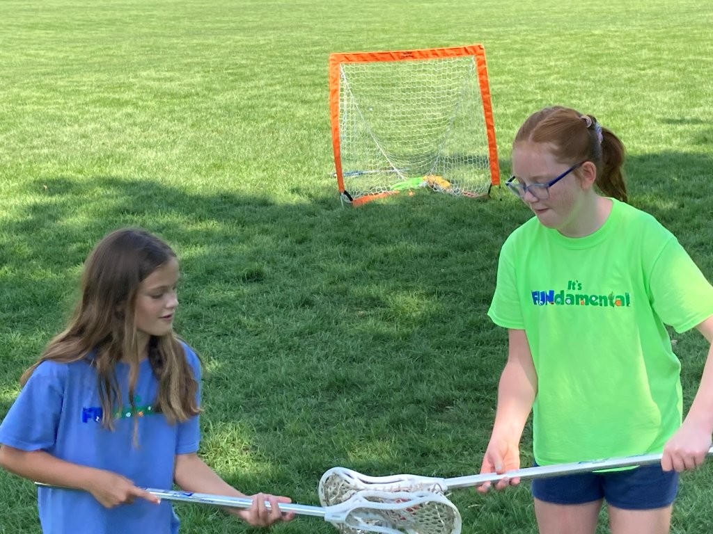 girls playing lacross at camp